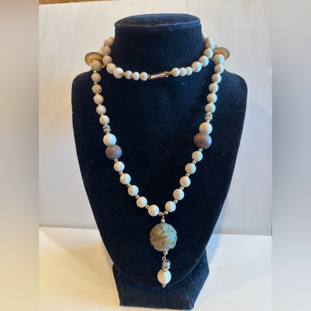 Vintage necklace with stone,wood,and gold accents. Has a craved stone pendant.